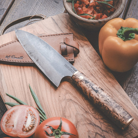 Roselli's handcrafted Santoku kitchen knife in high-carbon steel (UHC steel) with a stained curly birch handle. Delivered with a handmade leather sheath.